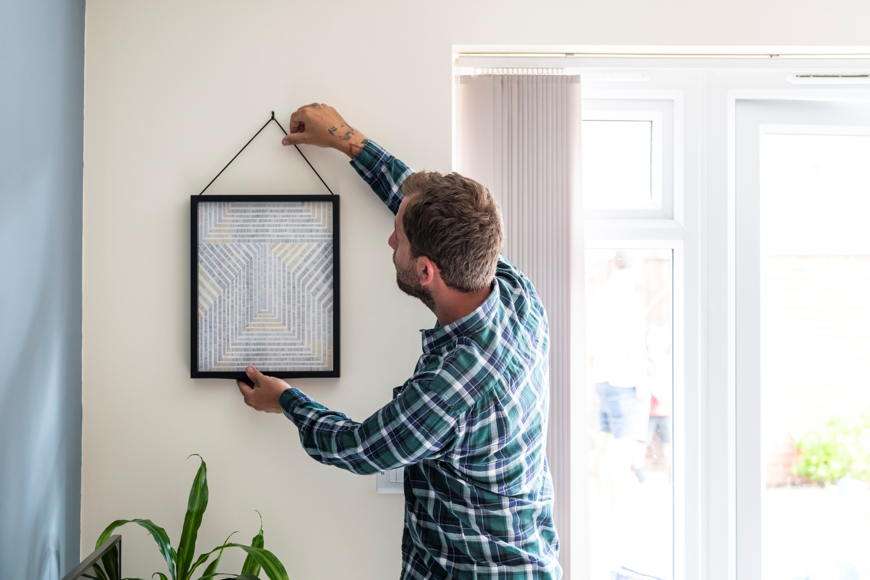 man hanging picture