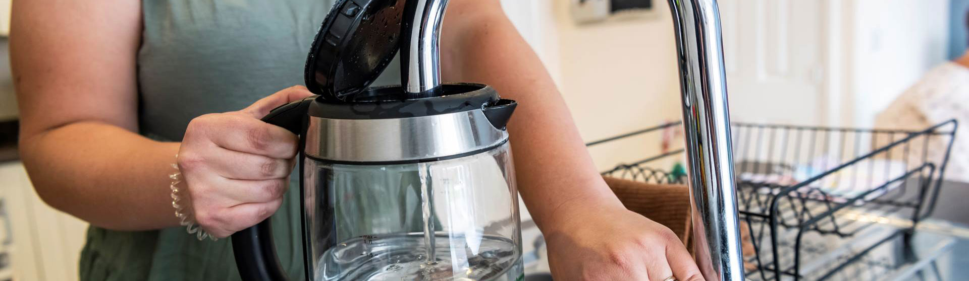 Person filling kettle up from the tap
