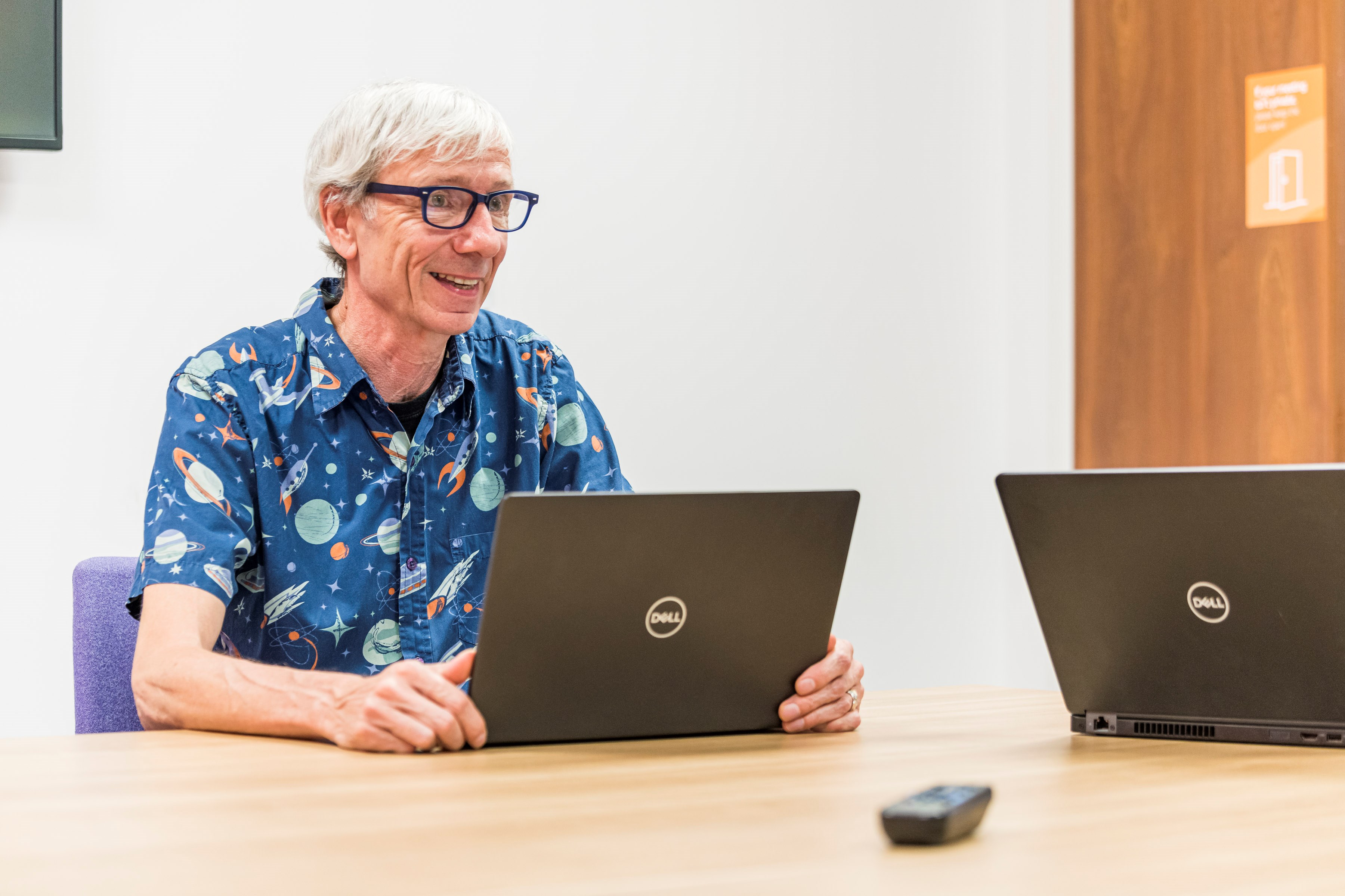 Man sitting at a computer screen smiling