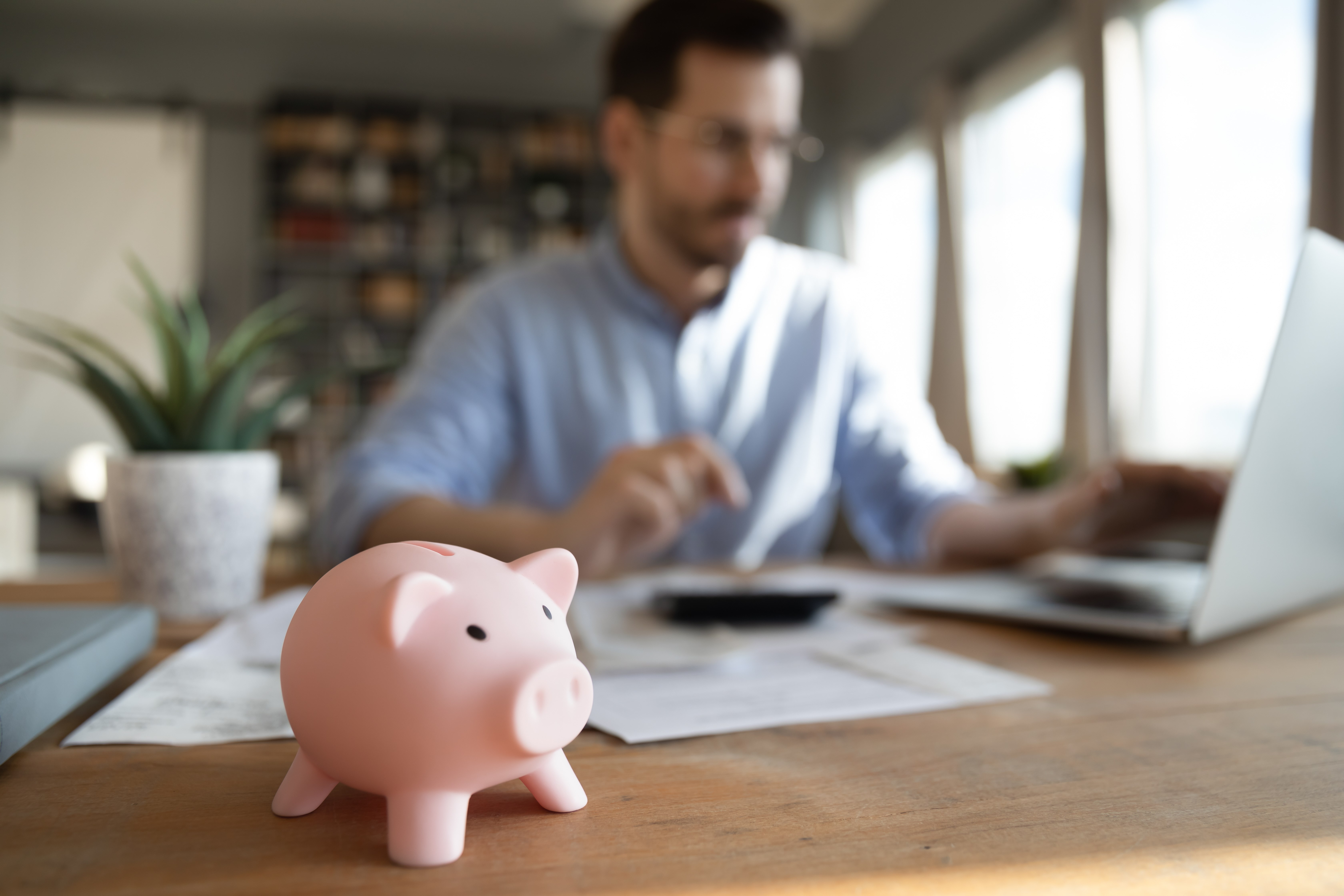 man on computer with piggy bank